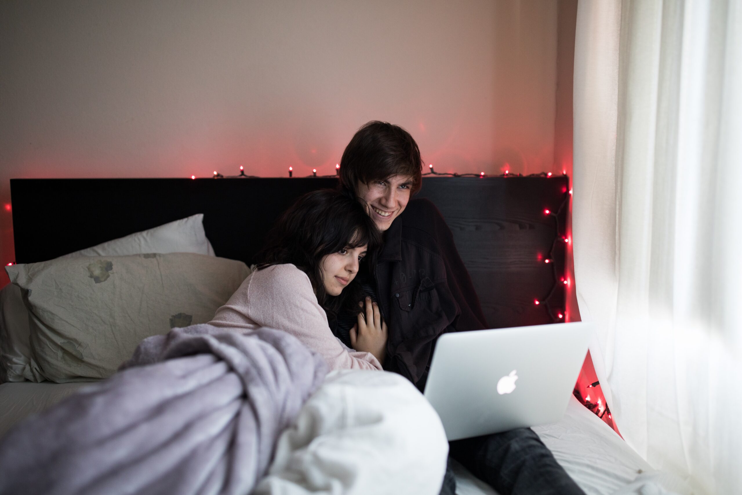 Couple regardant un ordinateur portable au lit